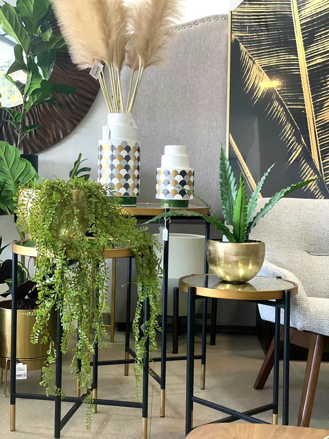 Sofá Chesterfield cojines dorados planta monstera